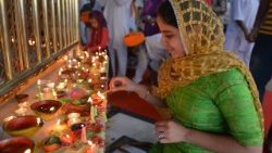 Woman in India lights a lamp for Deepavali 