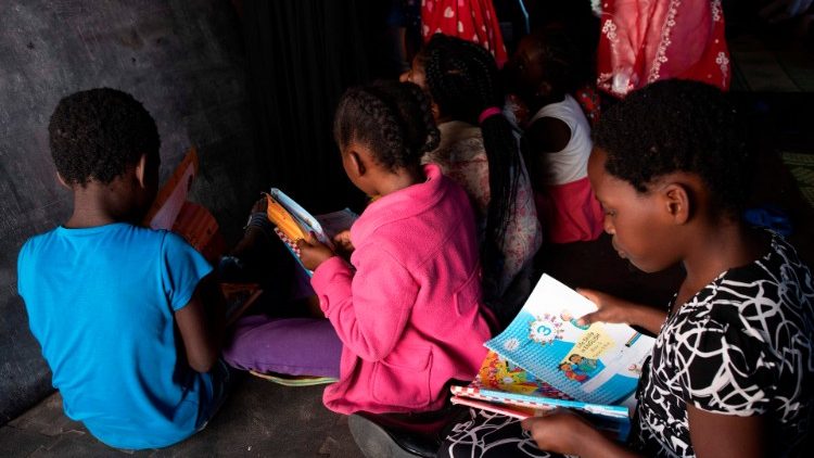 Children attending a makeshift school in a tent