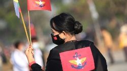 மியான்மார் நாட்டுப் பெண் கையில் கொடியுடன்