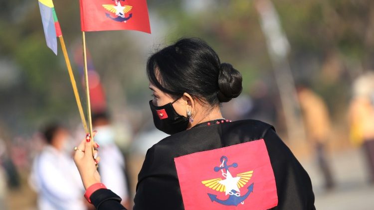 மியான்மார் நாட்டுப் பெண் கையில் கொடியுடன்