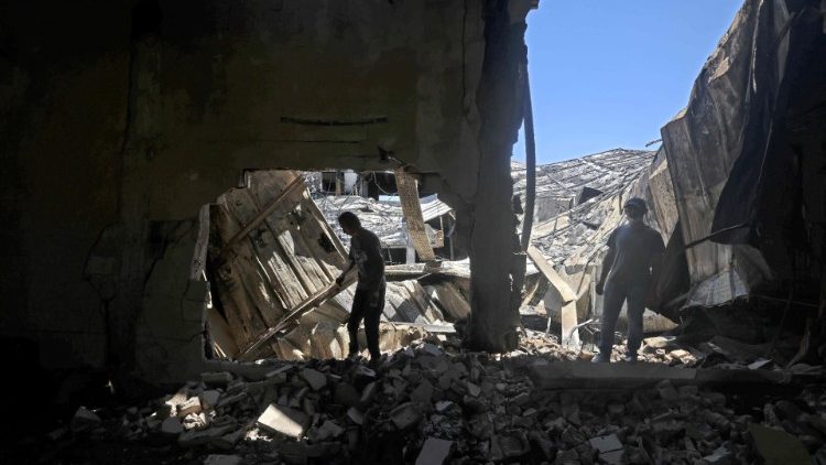 Palestinians dig through the rubble of a destroyed building in Gaza City