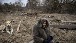 A woman sits in a area hit by shelling in Ukraine