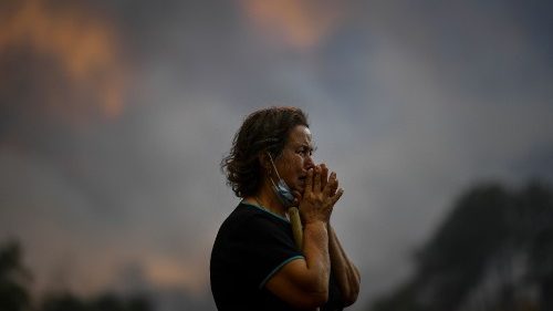Une femme observe l'avancée d'un feu de forêt à Orjais, à Covilha, dans le centre du Portugal, le 16 août 2022.