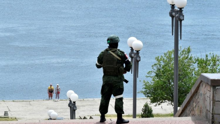 A Russian soldier patrols a river bank in Kherson