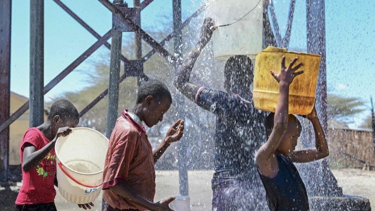 Children in the Horn of Africa fill their containers at a local borehole