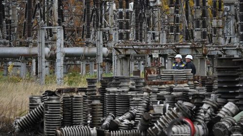 Workers examine damage after a missile strike on a power plant in Ukraine