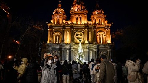 Pessoas tiram selfies em frente à Igreja de São José na véspera de Natal em Pequim, em 24 de dezembro de 2022. (Foto de Jade Gao / AFP)