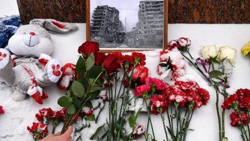 Uma pessoa deposita flores em memória dos mortos na greve de fim de semana em um quarteirão residencial na cidade ucraniana de Dnipro, no monumento à famosa poetisa ucraniana Lesya Ukrainka, em Moscou, em 17 de janeiro de 2023. (Foto da AFP)