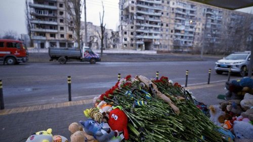 Flowers and toys are placed in a makeshift memorial in front of a residential building in Dnipro