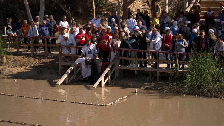 Christliche Pilger auf der jordanischen Seite des Jordans während einer Taufzeremonie