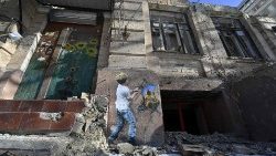 Uma fotografia tirada em 8 de fevereiro de 2023 mostra um mural do artista urbano italiano Tvboy na parede de um prédio residencial destruído em Kyiv, durante a invasão russa da Ucrânia. (Foto de Genya SAVILOV / AFP)