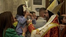 Menina iraquiana beija a cruz na Vigília Pascal na Igreja da Imaculada Conceição em Qaraqosh (Photo by Zais Al-Obeidi)