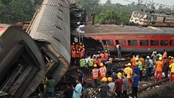 Rescue workers at site of three-train collision in India