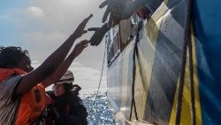 Seenotretter helfen einer Migrantin vor der Küste Siziliens
