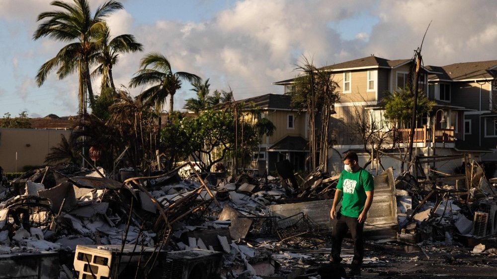 Um voluntário da Mercy Worldwide avalia os danos de um complexo de apartamentos carbonizado após um incêndio florestal em Lahaina, oeste de Maui, Havaí, em 12 de agosto de 2023. (Foto de Yuki IWAMURA/AFP)