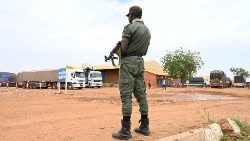 Ein Soldat steht neben rund 300 Lastwagen Wache, auf denen vor allem Lebensmittel aus Burkina Faso transportiert werden