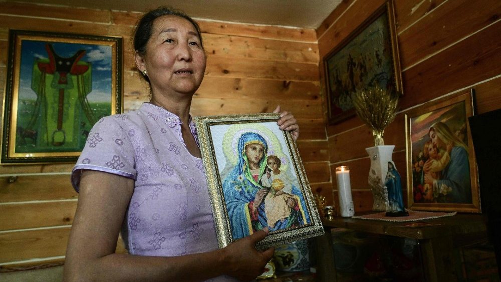 Otgontsetseg Dash-Onet, 62 anos, membro de uma família católica, segura uma foto de Maria e Jesus em sua casa em Ulan Bator em 31 de agosto de 2023. (Foto de Pedro PARDO/AFP)