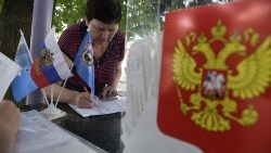 A woman receives her ballot papers at a polling station in Russian-occupied Donetsk