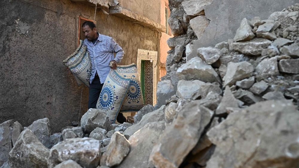 Um homem passa por casas destruídas na aldeia montanhosa de Moulay Brahim, na província central de al-Haouz, em 11 de setembro de 2023. O terremoto matou pelo menos 2.122 pessoas, feriu mais de 2.400 outras e destruiu aldeias inteiras. (Foto de Philippe LOPEZ/AFP)