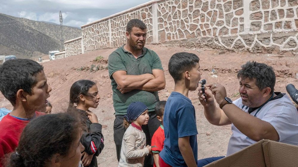 Um médico examina pessoas deslocadas em uma escola entre Marrakech e Taroudant, na montanha do Atlas. (Photo by BULENT KILIC / AFP)