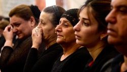Mourners attend a mass for the victims of the wedding hall fire in Qaraqosh
