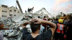 rescuers and civilians remove the rubble of a home destroyed following an Israeli attack on the town of Deir Al-Balah in the central Gaza Strip