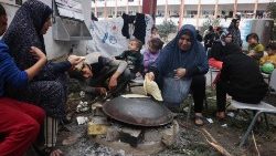 Vertriebene Palästinensische Frauen bereiten auf dem Gelände einer Schule im südlichen Gaza-Streifen Brot zu 