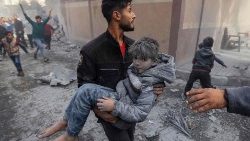 Muž nesoucí zraněné dítě po bombardování města Rafah v jižní části Pásma Gaza, 20. listopadu 2023