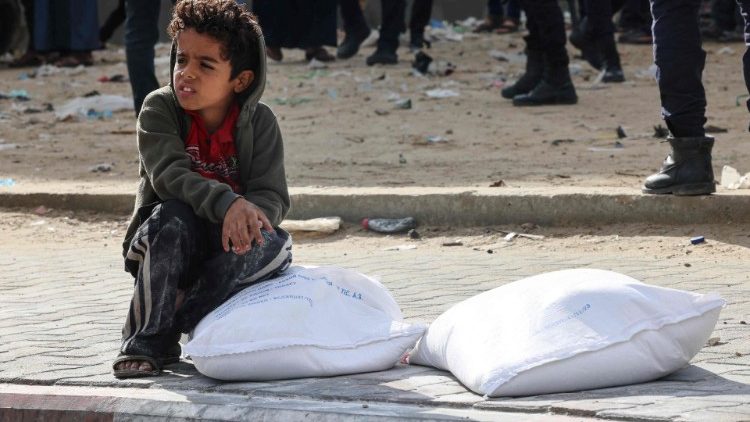संयुक्त राष्ट्र से राशन प्राप्त करता एक फिलीस्तीनी बच्चा