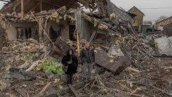 Anwohner stehen neben einem zerstörten Haus nach einem russischen Angriff in Kyiv am 11. Dezember 2023