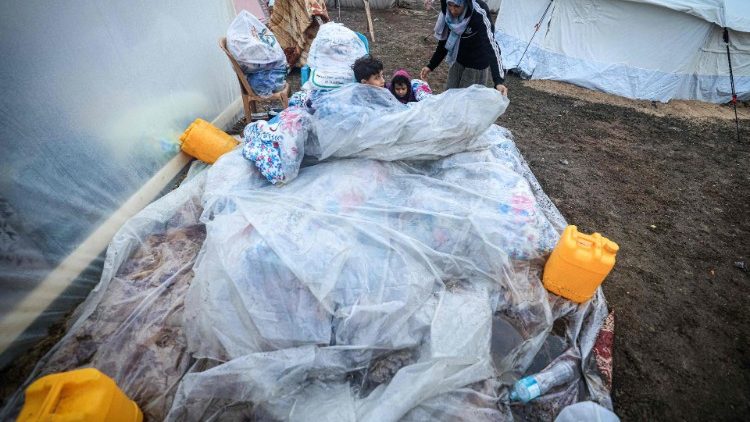 Displaced Palestinian children in Rafah seek warmth under plastic sheets