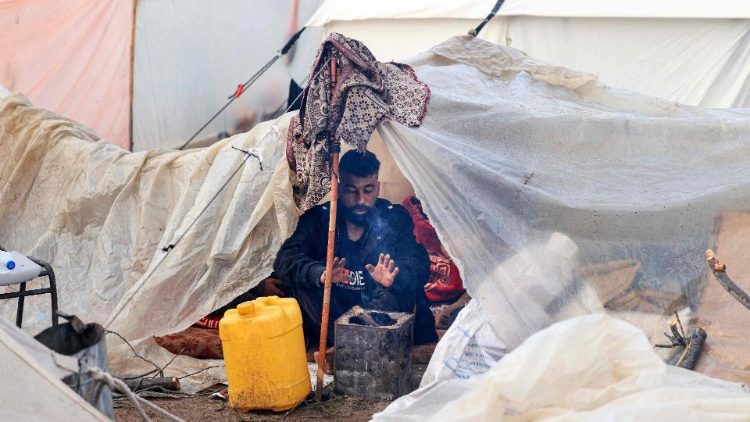 A displaced Palestinian man in his makeshift tent at a camp in Rafah