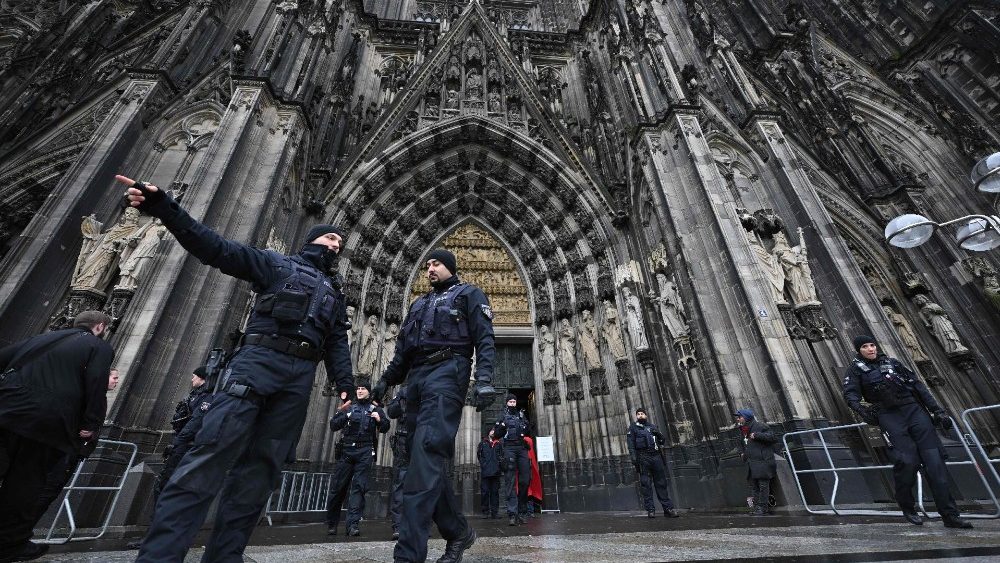 Policiais estão em frente à Catedral de Colônia em 24 de dezembro de 2023. A polícia alemã anunciou na noite de 23 de dezembro de 2023 que estava revistando a catedral na cidade ocidental de Colônia com cães farejadores após um "aviso de perigo" para a véspera de Ano Novo. O diário alemão Bild informou que autoridades na Áustria, Alemanha e Espanha receberam indicações de que um grupo islâmico estava a planear vários ataques na Europa, possivelmente na véspera de Ano Novo e no Natal. (Foto de INA FASSBENDER/AFP)