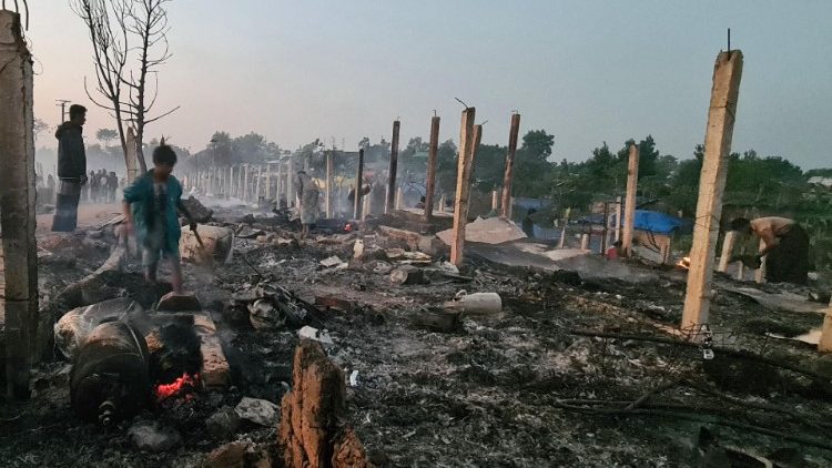 Rohingya refugees look through the debris of their houses charred by a devastating fire at the Ukhia camp, Cox's Bazaar in the early hours of January 7