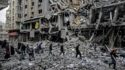 Palestinians walk amid the rubble of destroyed houses in Gaza