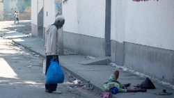 Ein Mann auf der Straße in Port-au-Prince hält an, um einer Frau zu helfen, die in den Fuß geschossen wurde. Immer wieder geraten Unbeteiligte ins Kreuzfeuer der Gangs