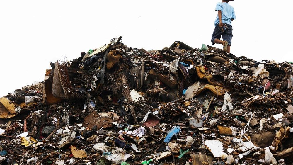Uma criança caminha sobre um lixão temporário com entulhos de enchentes no bairro Vila Farrapos, Porto Alegre, Rio Grande do Sul, Brasil, em 17 de junho de 2024. Toneladas de lixo ainda cobrem as ruas de Porto Alegre após as enchentes que atingiram a cidade . (Foto de SILVIO ÁVILA/AFP)