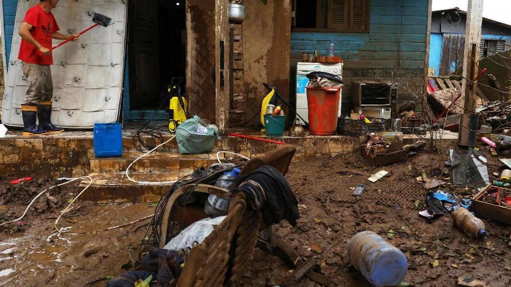 Um homem limpa sua casa na Ilha Grande dos Marinheiros, Porto Alegre, Rio Grande do Sul, Brasil, em 17 de junho de 2024. Toneladas de lixo ainda cobrem as ruas de Porto Alegre após as enchentes que atingiram a cidade. (Foto de SILVIO ÁVILA/AFP)