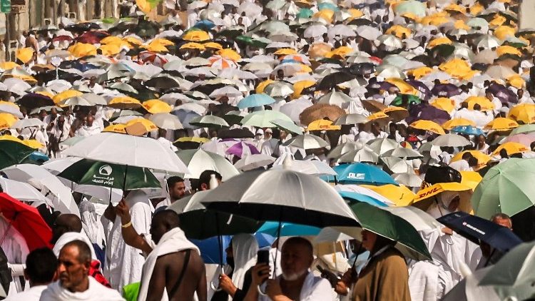 Muslim pilgrims use umbrellas to shade themselves from the sun as they arrive at the base of Mount Arafat