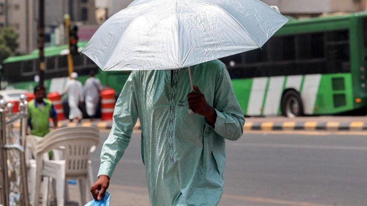 Ein Mann schützt sich in Mekka mit einem Regenschirm vor der Sonne 