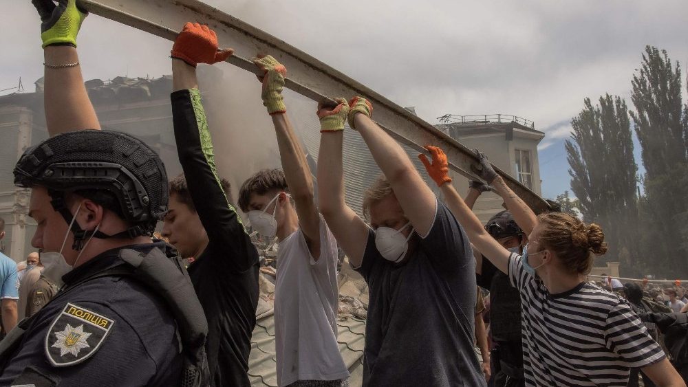 Policiais e outros ajudam a limpar os escombros do prédio destruído do Hospital Infantil Ohmatdyt após um ataque com mísseis russos na capital ucraniana, Kiev, em 8 de julho de 2024, em meio à invasão russa na Ucrânia. (Foto de Roman PILIPEY/AFP)