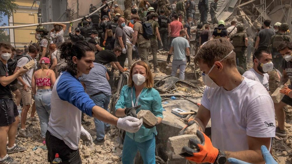 Voluntários, incluindo médicos, ajudam o pessoal de emergência e resgate a limpar os escombros de um prédio destruído no Hospital Infantil Ohmatdyt após um ataque com mísseis russos na capital ucraniana, Kiev, em 8 de julho de 2024, em meio à invasão russa na Ucrânia. (Foto de Roman PILIPEY/AFP)