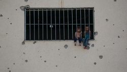 Niños palestinos sentados en el marco de una ventana de la prisión central de Asdaa, convertida en refugio para personas desplazadas 