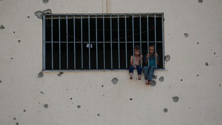Niños palestinos sentados en el marco de una ventana de la prisión central de Asdaa, convertida en refugio para personas desplazadas 