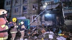 Des pompiers ukrainiens tentent d'éteindre un feu dans un immeuble résidentiel après une attaque de missiles à Kharkiv. 