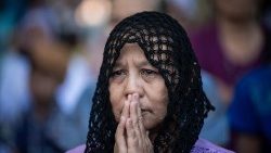 Eine Frau betet an Allerheiligen 2025 auf einem Friedhof in Myanmar