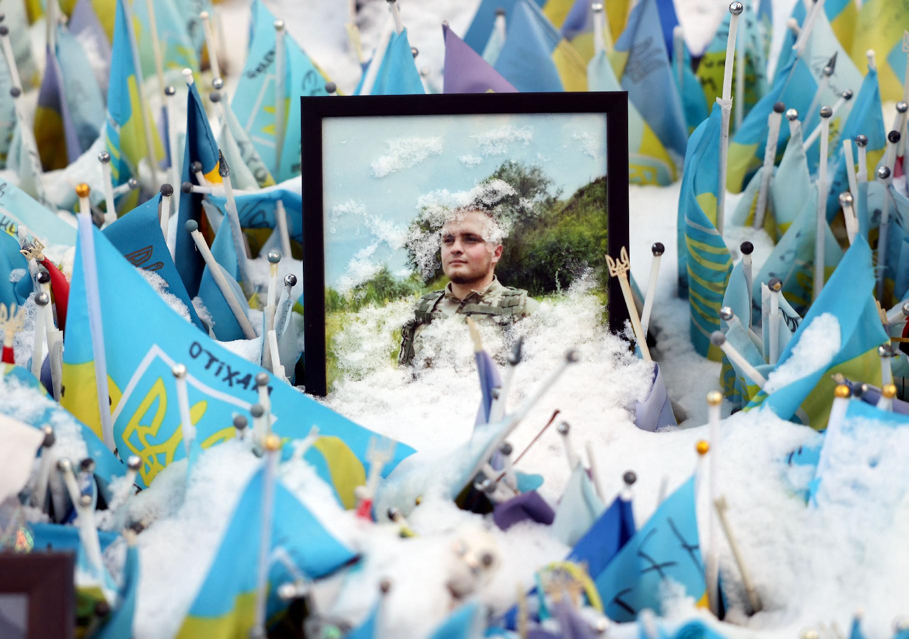 O retrato do soldado ucraniano morto, salpicado de neve, foi instalado em um memorial improvisado para os soldados ucranianos mortos na Praça da Independência, em Kiev, em 12 de dezembro de 2024, em meio à invasão russa na Ucrânia. (Foto de Anatolii STEPANOV / AFP)