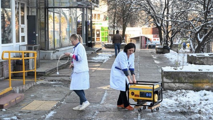 Funcion&aacute;rios movem um gerador que abastece uma farm&aacute;cia com eletricidade durante uma queda de energia na cidade de Lviv, no oeste da Ucr&acirc;nia, em 13 de dezembro de 2024, em meio &agrave; invas&atilde;o russa da Ucr&acirc;nia. A R&uacute;ssia lan&ccedil;ou um dos seus maiores ataques de m&iacute;sseis nas primeiras horas de 13 de dezembro de 2024, visando a rede el&eacute;trica da Ucr&acirc;nia enquanto as temperaturas ca&iacute;am abaixo de zero, no que Moscou chamou de ataque retaliat&oacute;rio por Kiev ter disparado armas dos EUA em um campo de avia&ccedil;&atilde;o no sul da R&uacute;ssia no in&iacute;cio desta semana. (Foto de YURIY DYACHYSHYN / AFP)