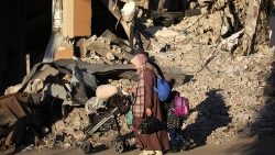 Palestinians evacuate their homes at the Bureij refugee camp