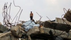 A Palestinian man stands on the rubble of a destroyed building in central Gaza